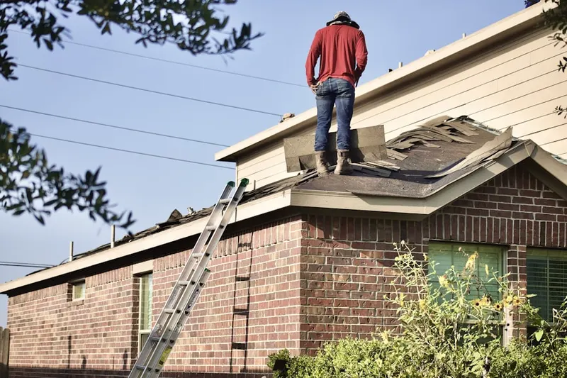 Professional roofer working on a residential roof in Falls Hill